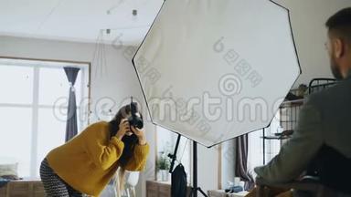 专业摄影师女摄影师在摄影棚用数码相机拍摄商人模特女
